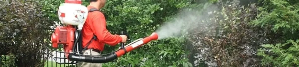 Mosquito control technician fogging shrubs and landscaping for mosquito treatment in Chattanooga, TN