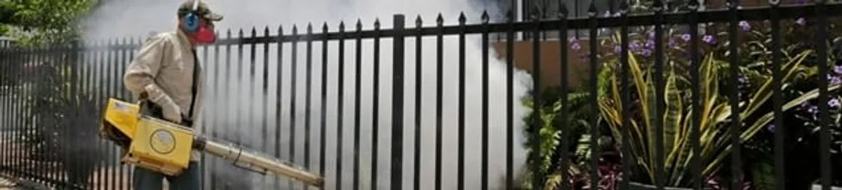 Mosquito control technician fogging a yard perimeter for mosquito reduction in Chattanooga, TN